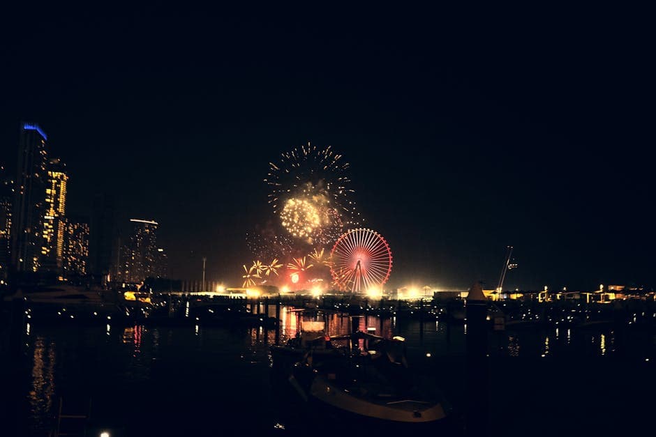 Bournemouth Pier illuminated at night with fireworks reflecting on the sea